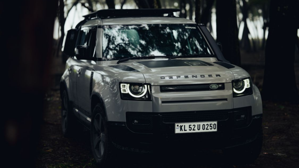 A classic Land Rover Defender driving in a river, iconic among Old SUVs.