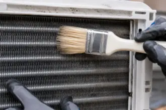 A detailed view of professional window ac unit maintenance on aluminum fins