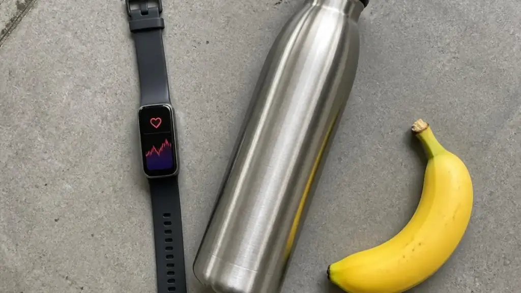  flatlay of fitness tracker and hydration bottle for monitoring physical activity recommendations.

