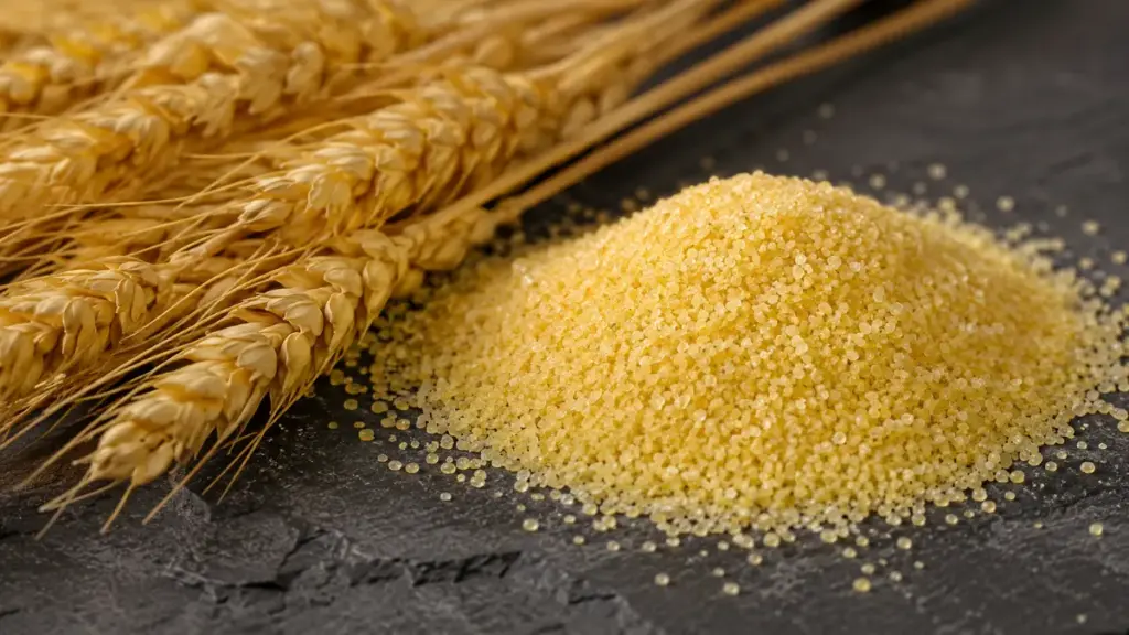 coarse-golden-durum-semolina-flour-granules-on-slate-with-wheat-stalks