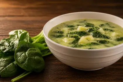 creamy spinach and potato soup served in a white ceramic bowl