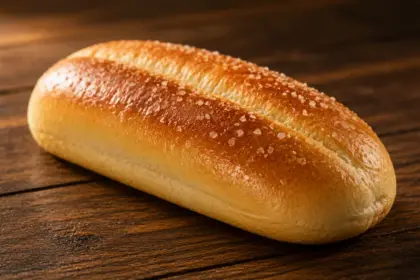 freshly baked golden potato bun on a dark wooden table