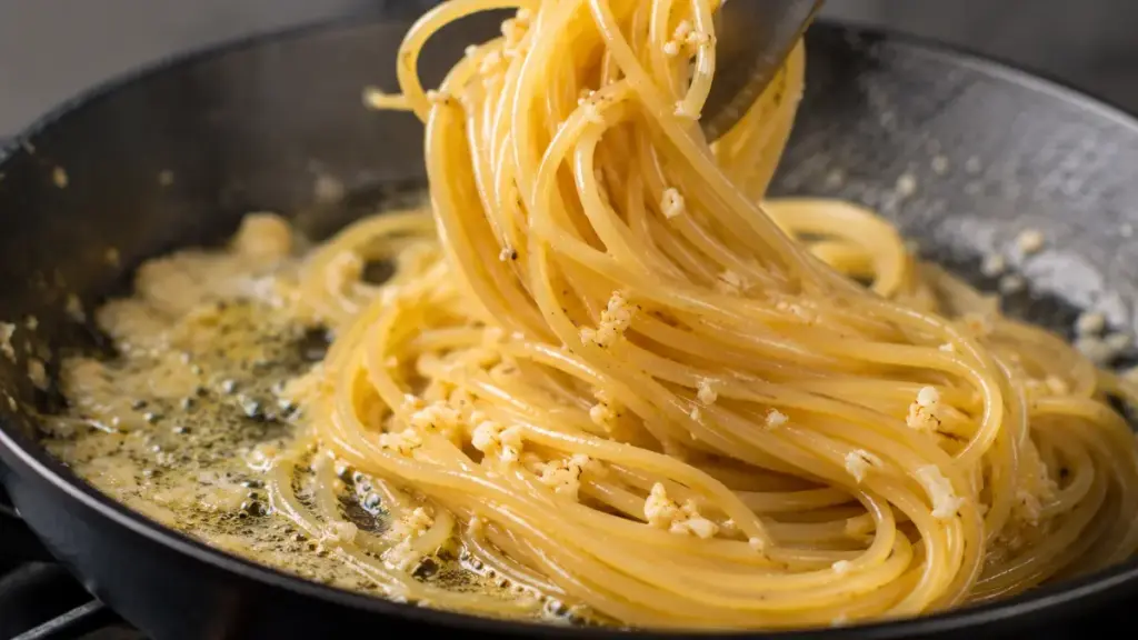long-spaghetti-strands-tossed-in-garlic-butter-inside-a-cast-iron-pan
