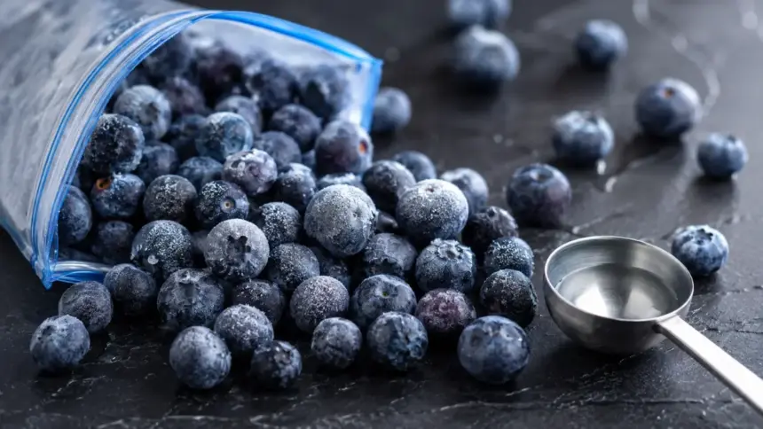 open bag of frozen blueberries spilled on a countertop
