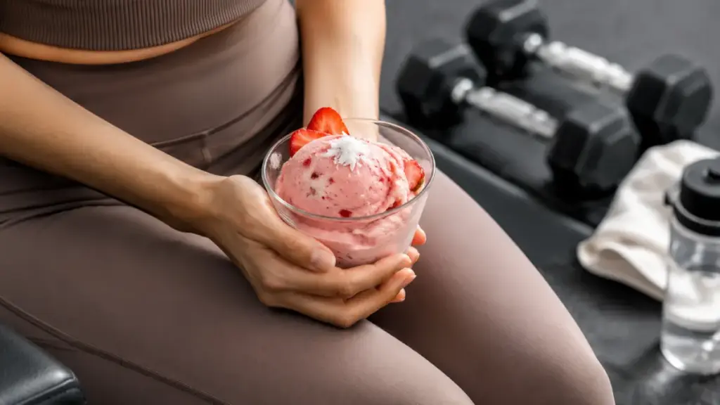 person-resting-on-a-bench-holding-a-cup-of-strawberry-sorbet