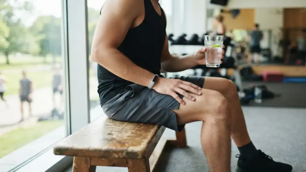 person-sitting-on-a-bench-holding-a-glass-of-fresh-water-thecouch