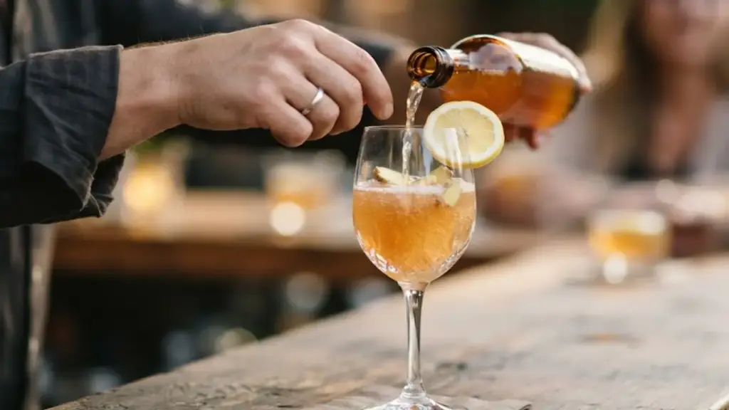 pouring-chilled-ginger-kombucha-into-a-wine-glass-to-substitute-alcoholic-beverages