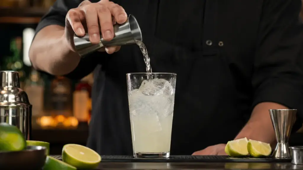precision-bartender-measuring-clean-tequila-over-fresh-lime-juice-for-skinny-summer-cocktail-drinks