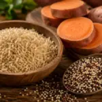 raw brown rice and sweet potatoes on a wooden table