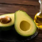 sliced fresh green avocado and olive oil on a slate plate aft
