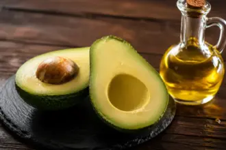 sliced fresh green avocado and olive oil on a slate plate aft