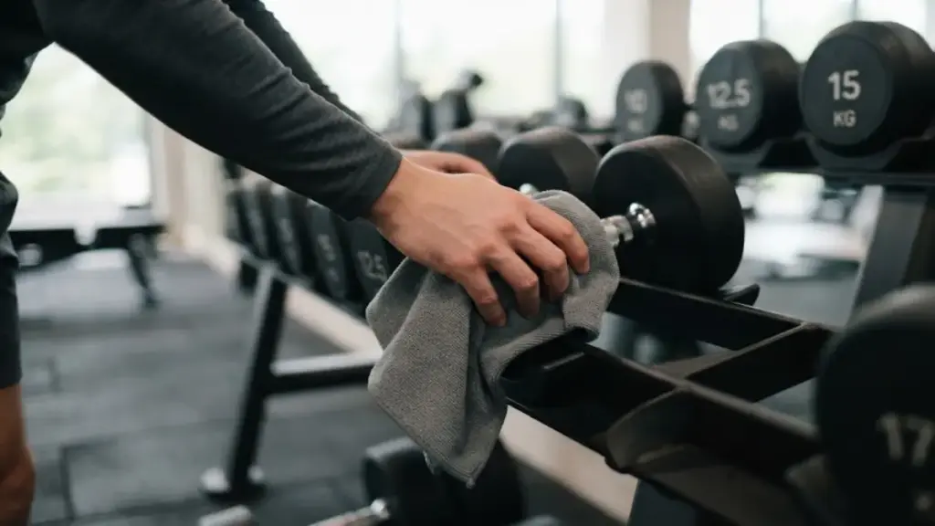 wiping-a-metal-dumbbell-with-a-clean-white-cloth