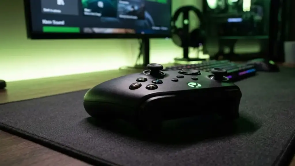 xbox-controller-resting-on-desk-mat-with-green-led-backlight-for-xbox-game-pass-essential
