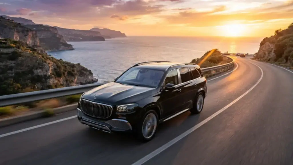 A Maybach GLS driving on a coastal road during sunset showcasing its luxury design
