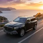 A Maybach GLS driving on a coastal road during sunset showcasing its luxury design
