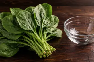 fresh green leafy vegetable placed next to a glass bowl on a table